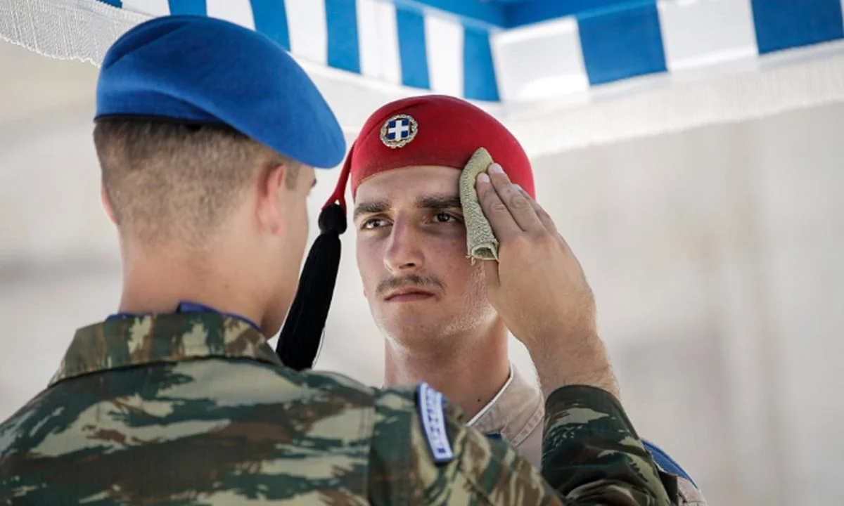 Οι Εύζωνες στέκονται στο λιοπύρι της Αθήνας υπηρετώντας ένα ιερό καθήκον και δυστυχώς λίγοι δίνουν σημασία στη θυσία τους.