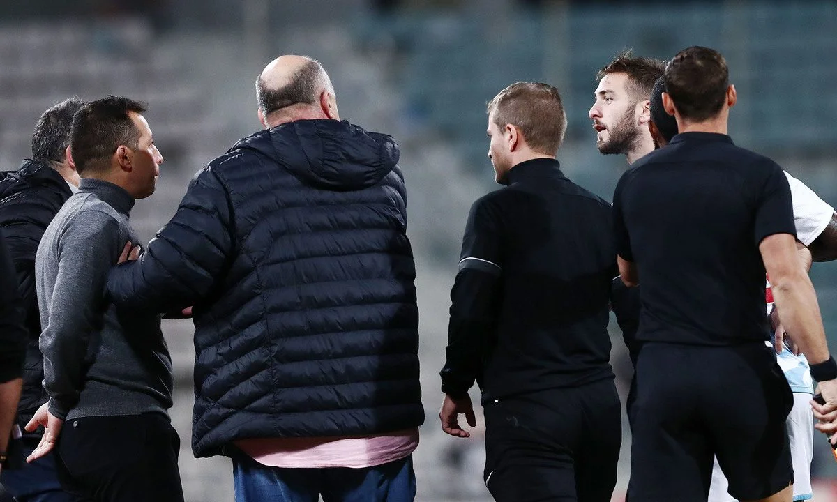 Ο Αχιλλέας Μπέος συνέβαλε τα μέγιστα στο να προστατευθούν ποδοσφαιριστές και διαιτητές, αλλά και στην ολοκλήρωση του Βόλος - Ολυμπιακός. Οι κουβέντες του στα αποδυτήρια.