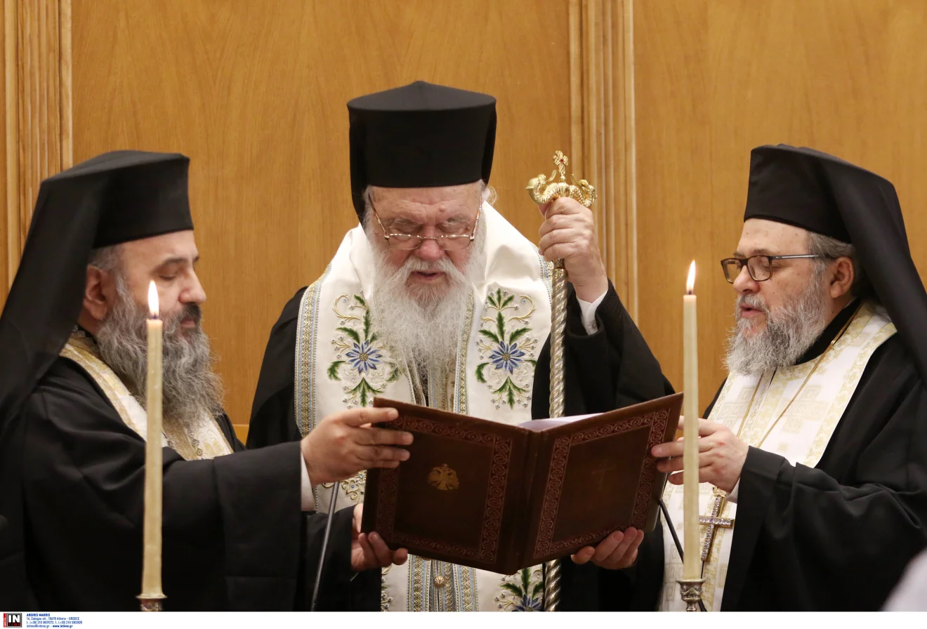 ερείς τελούν ακολουθία κρατώντας ανοιχτό λειτουργικό βιβλίο, σε κατανυκτική στιγμή με αναμμένες λαμπάδες και εκκλησιαστική ατμόσφαιρα. Πηγή: INTIME