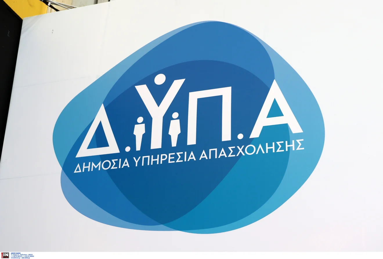 Το λογότυπο της ΔΥΠΑ εμφανίζεται σε κεντρικό σημείο, με φόντο ανοιχτόχρωμη επιφάνεια και έντονα μπλε στοιχεία. Η εικόνα παραπέμπει σε προγράμματα απασχόλησης, επιδοτούμενες θέσεις εργασίας και δράσεις για ανέργους. Πηγή: ΙΝΤΙΜΕ.