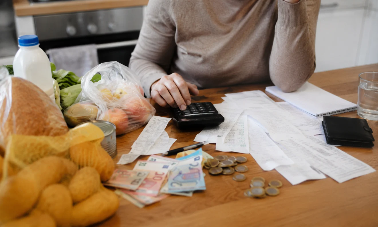 Νοικοκυριό υπολογίζει έξοδα καθημερινών αγορών, με τρόφιμα, αποδείξεις και μετρητά πάνω στο τραπέζι, σε εικόνα που αποτυπώνει την πίεση της ακρίβειας. Πηγή: sportime.gr.