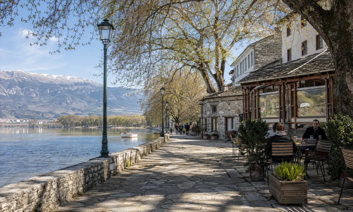 Περίπατος δίπλα στη λίμνη των Ιωαννίνων με το κάστρο και την πόλη στο βάθος / Εικόνα: AI