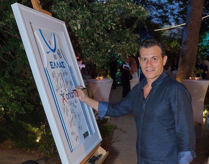 Ο Δημήτρης Ιτούδης υπογράφει τη φανέλα της Εθνικής Ομάδας, που δόθηκε ως δώρο στη διοίκηση του ΟΠΑΠ από την Ελληνική Ομοσπονδία Καλαθοσφαίρισης